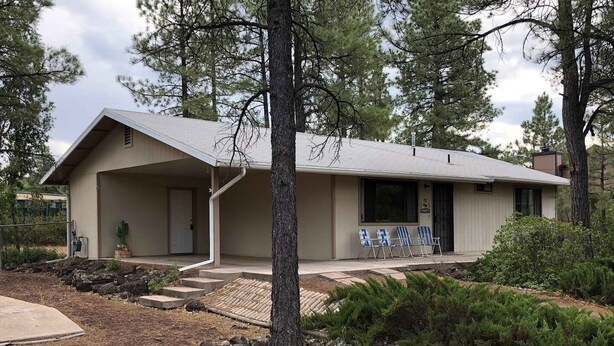 A single-story building with a covered porch, a door, and a window. - Ken`s Retreat- Come relax in our home (Navajo County)