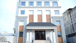 A modern hotel with a symmetrical facade, large windows, and a central entrance with a dark-colored door. - Prakash Continental (Bareilly)