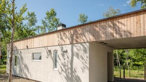 Un edificio moderno con techo plano, ventanas amplias y base de hormigón.