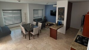 A modern kitchen with a dining area, a built-in oven, and a TV mounted on the wall. - Tacho's family hause, 5-star safe (La Paz)