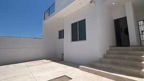 A modern two-story building with a flat roof, large windows, and a staircase leading to the entrance. - Tacho's family hause, 5-star safe (La Paz)