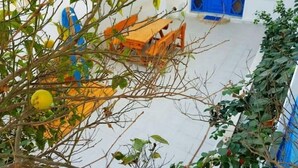 A courtyard with a blue door, orange furniture, and greenery. - Welcome to Dar Jaafar! Cozy Arabesque Style Holiday House in la Marsa Tunisie (La Marsa)