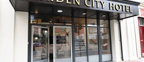 The exterior of the Maiden City Hotel with a prominent sign above the entrance.