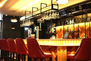 Un bar con sillas rojas, una barra de madera y un letrero que dice THE SPIRE.