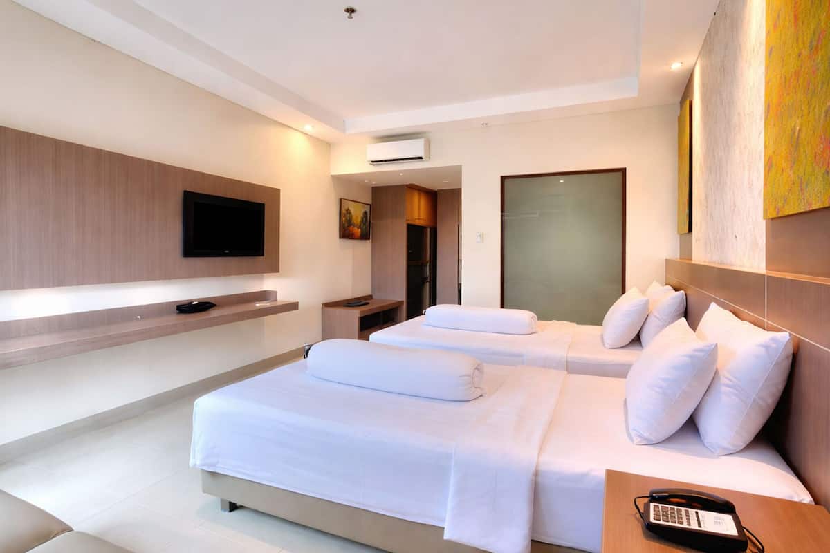A modern hotel room with a large bed, a flat-screen TV, a bedside table with a phone, and a painting on the wall.