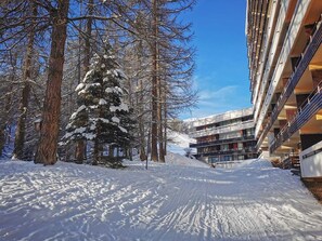 A snow-covered path leading to a modern building with multiple balconies and a ski lift visible in the background. - Hiking & Activities at the foot of the mountains - PELVOUX II - VARS (VARS)