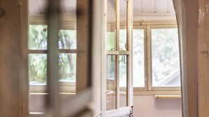 Ein Zimmer mit großem Fenster, einer Tür mit Griff und einer sichtbaren Wand.
