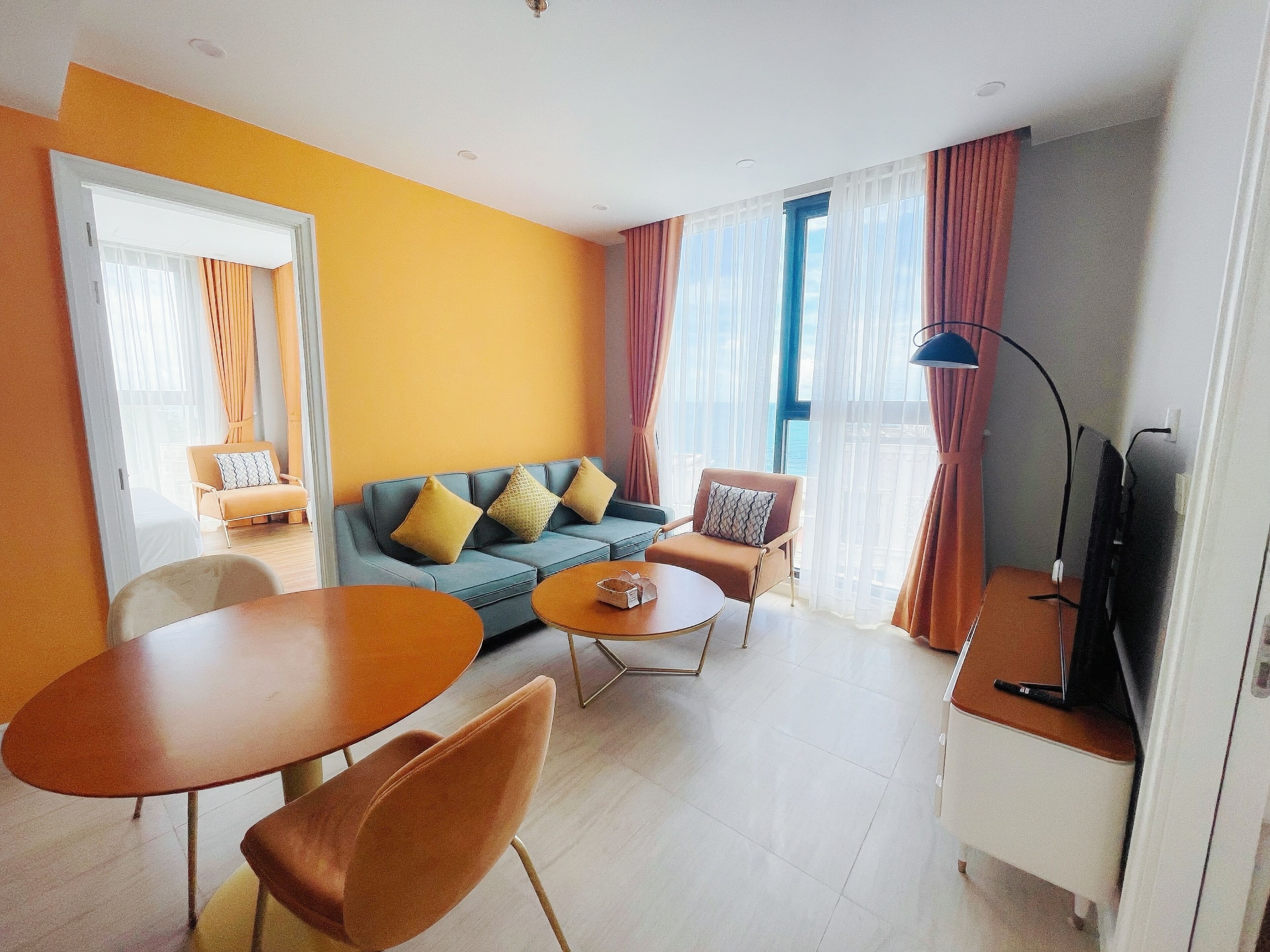 Una sala de estar moderna con un sofá, dos sillones, una mesa de centro y un mueble para televisión.