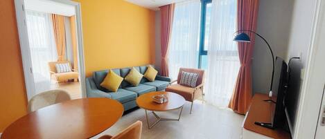 Una sala de estar moderna con un sofá, dos sillones, una mesa de centro y un mueble para televisión.