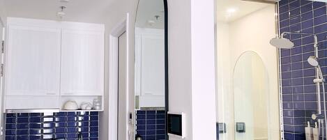 A modern bathroom with a shower, a mirror, and a sink.