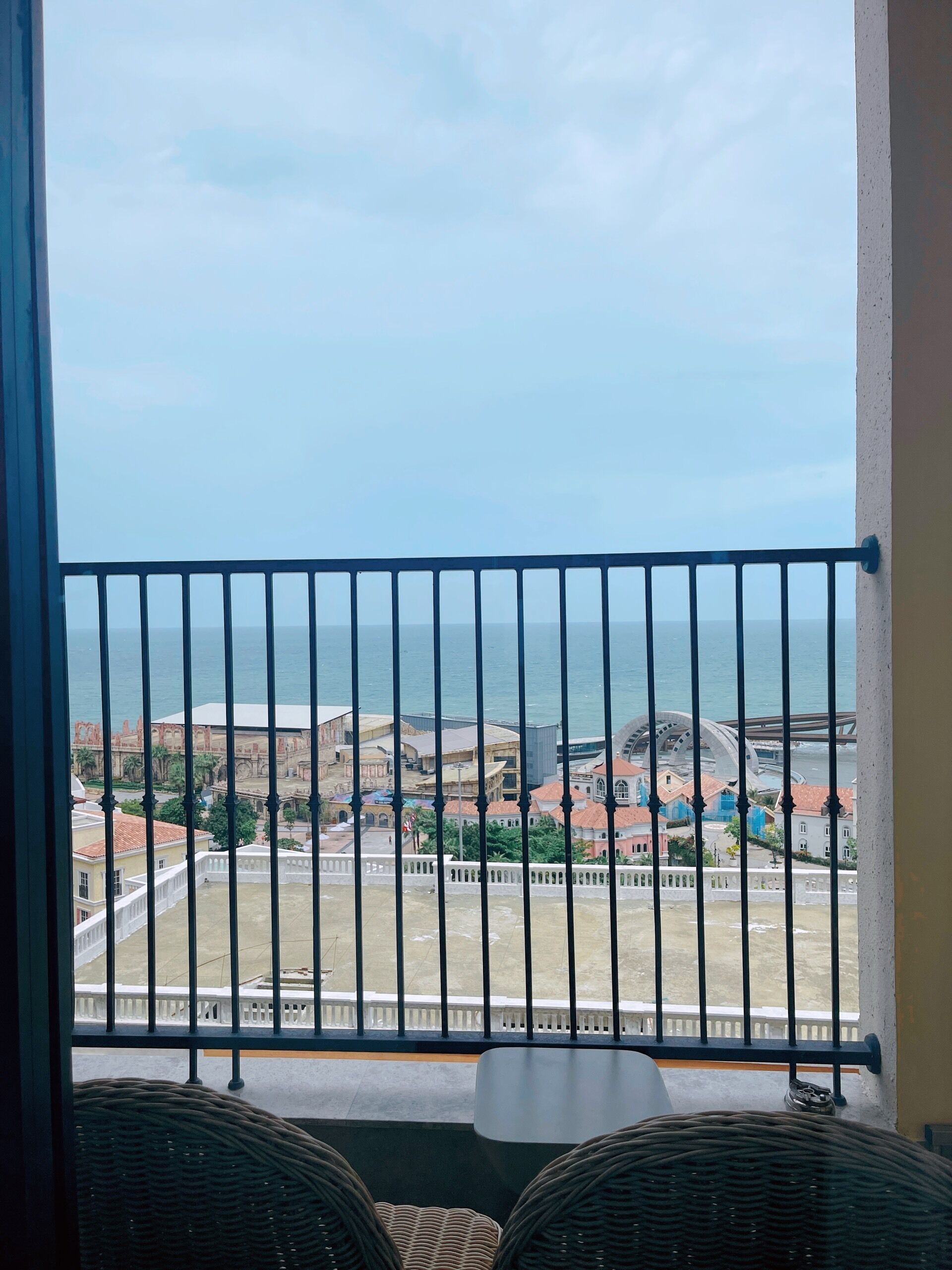 A balcony with a view of the sea and buildings.