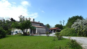 Una casa con jardín, entrada para vehículos y garaje.