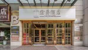 A hotel entrance with glass doors and a sign above.