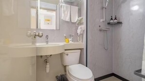 A modern bathroom with a toilet, sink, and shower.