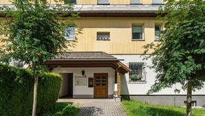 Un bâtiment doté d’une entrée en bois, d’un chemin pavé et d’un petit espace jardin.