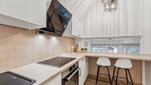 Una cocina moderna con horno empotrado, microondas y ventana con vistas al exterior.