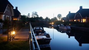 Ein Kanal mit Booten, ein Haus links und ein weiteres rechts.