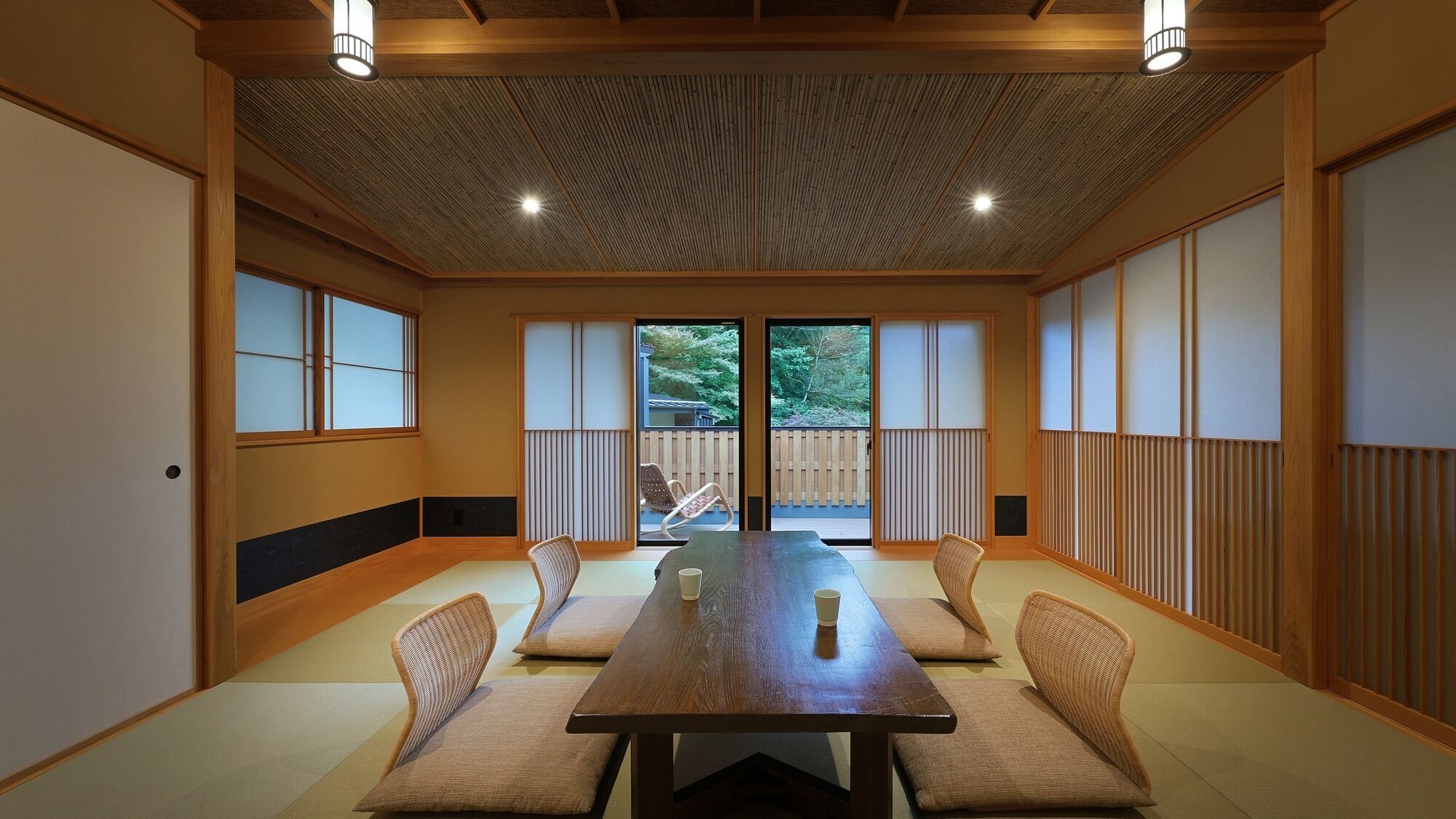 A traditional Japanese-style room with tatami flooring, a low wooden table, and shoji screens.