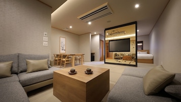 A modern living room with a sofa, coffee table, and a TV area with a sliding door.