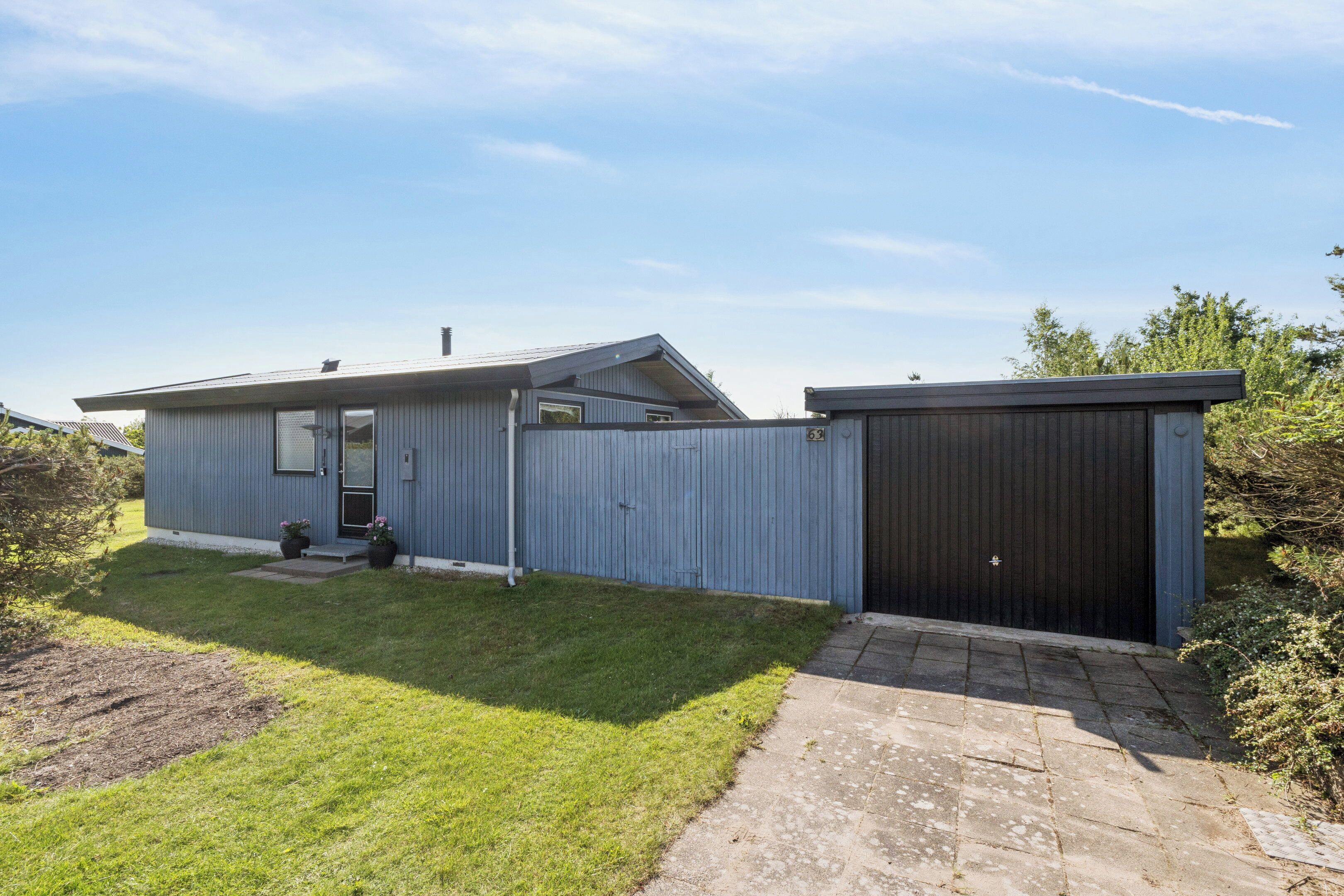 A single-story building with a garage, a small front porch, and a well-maintained lawn.