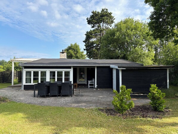 A modern house with a covered patio, a dining area, and a garage.