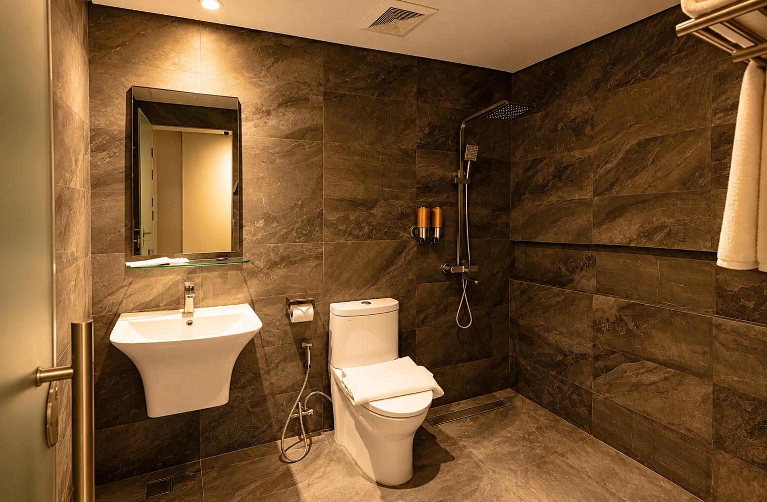 Une salle de bain moderne équipée d’un lavabo, de toilettes et d’une douche.