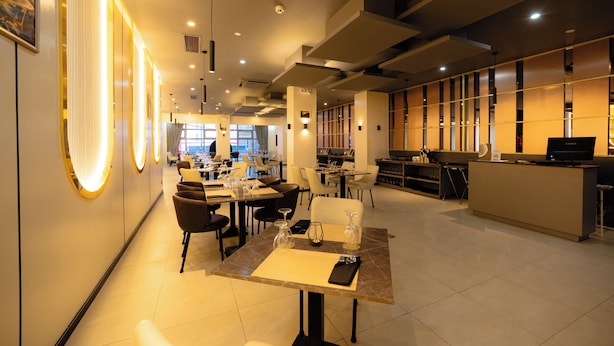 Ein modernes Restaurant mit Tischen, Stühlen und einer Bar.