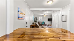 A spacious room with a large wooden table, a sofa, and a ceiling fan.