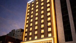 A modern hotel with a prominent entrance, multiple floors, and a well-lit facade. - Randor Hotel Sapporo Prestige (Sapporo)