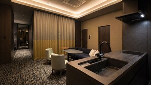 A hotel room with a kitchenette, a sofa, a small round table, and a separate dining area. - Randor Hotel Sapporo Prestige (Sapporo)