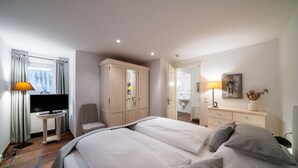 A hotel room with a bed, a TV, a desk, and a wardrobe.