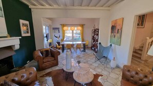 Una sala de estar con un sofá de cuero marrón, una mesa de centro y un comedor con sillas amarillas y una mesa.