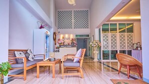 Um hall amplo com balcão de recepção, área de estar e vista para o exterior.