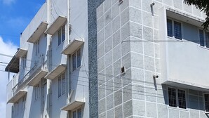 En byggnad med flera våningar, balkonger och en fasad med en tydlig struktur.