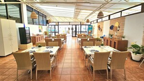 A spacious restaurant with high ceilings, large windows, and wicker furniture. - VALLE MARINA APARTAMENTOS (Arguineguin)
