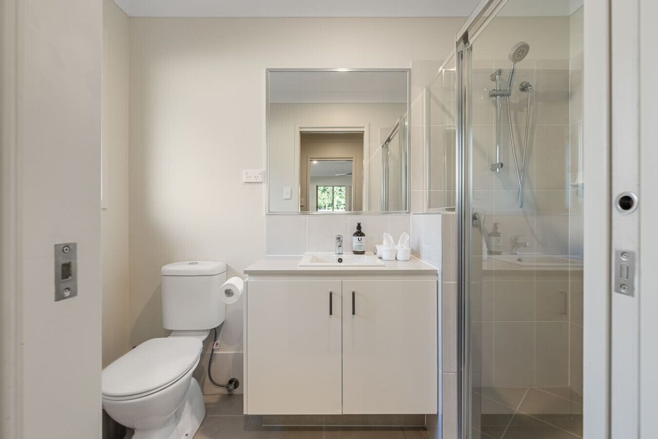 A modern bathroom with a toilet, sink, and shower.