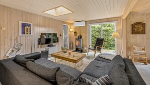 Ein gemütliches Wohnzimmer mit Kamin, Fernseher und bequemen Sitzmöglichkeiten.