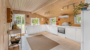 Eine moderne Küche mit weißen Schränken, einem eingebauten Backofen und einem großen Fenster für natürliches Licht.