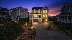A two-story house with a balcony, a front porch, and a staircase leading to the entrance.