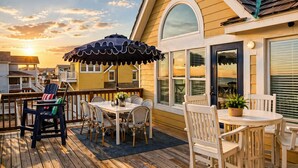 A deck with outdoor furniture, a table, and chairs.