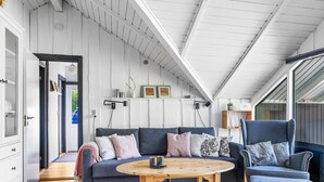 Una sala de estar acogedora con un sofá azul, una mesa de centro redonda de madera y un sillón azul.