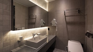 A modern bathroom with a large sink, mirror, towel rack, and toilet. - 21heritage hotel (Wonju)