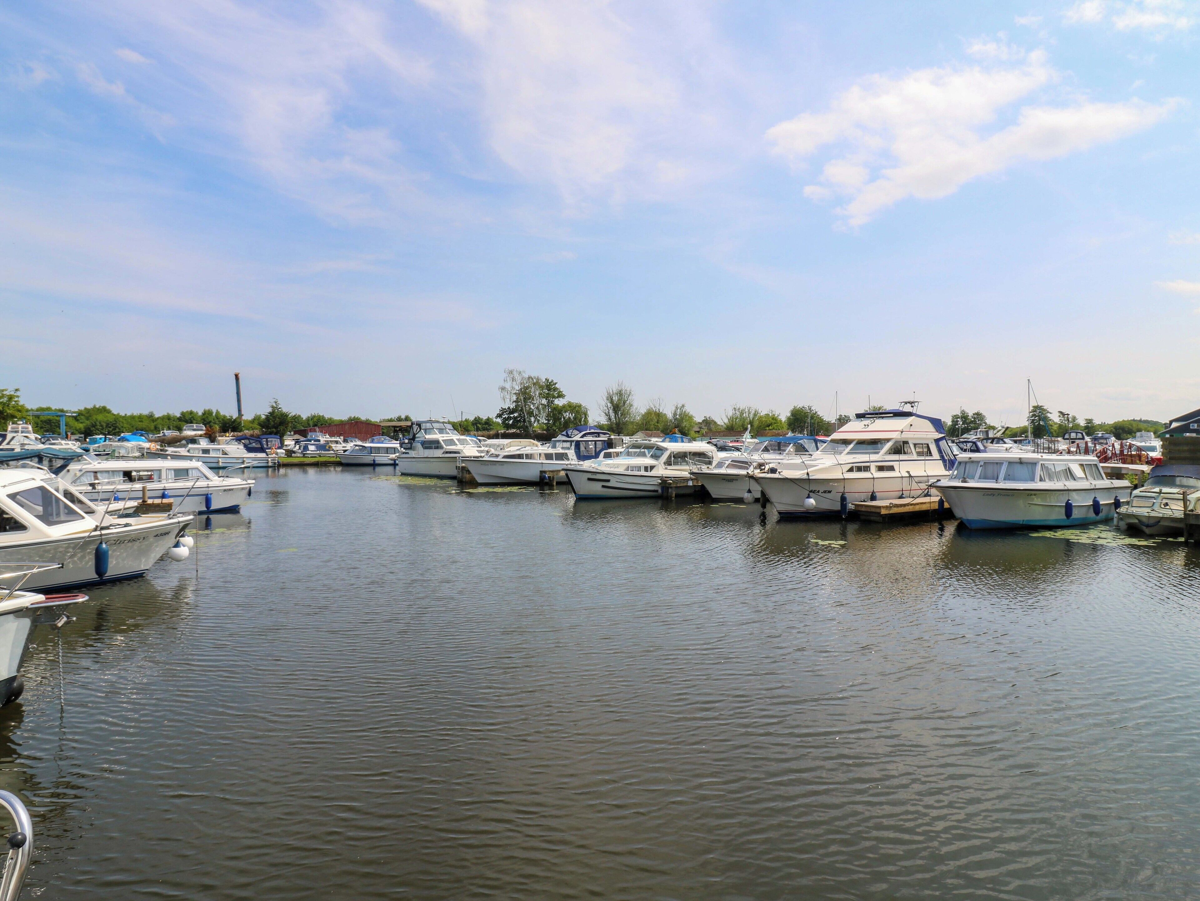 A marina with multiple boats docked in calm water.