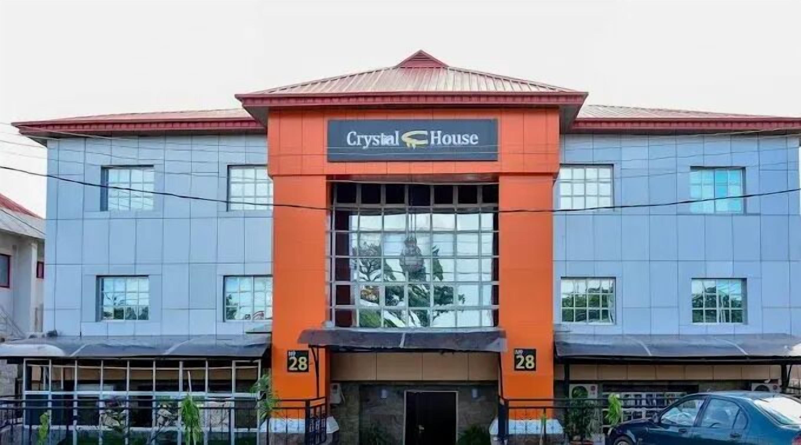 A building with a sign reading "Crystal House" and the number 28 on its facade.