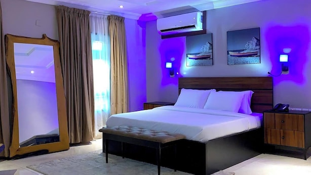 Ein modernes Schlafzimmer mit einem großen Bett, einem Spiegel und einem Nachttisch.