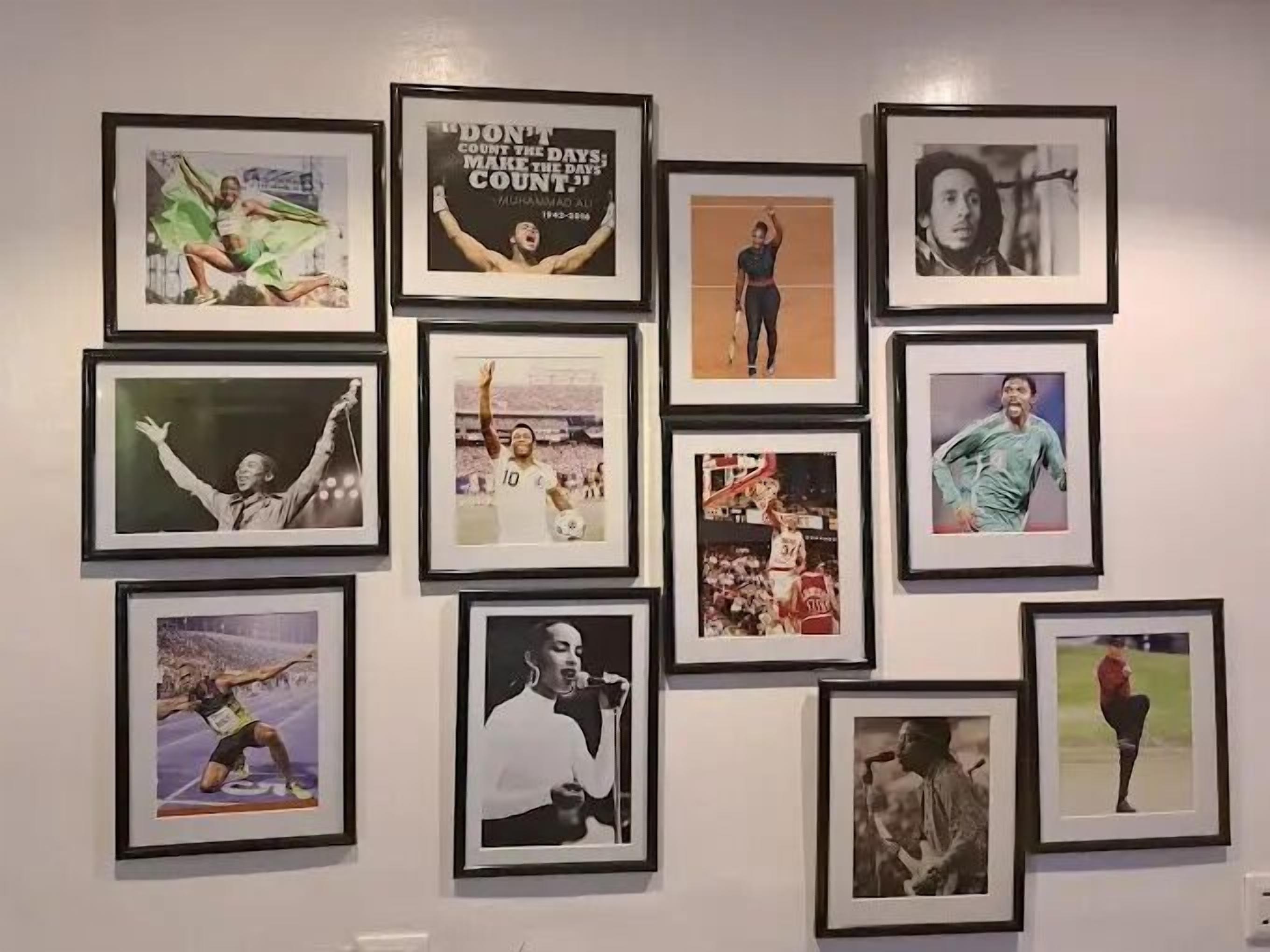 En væg med flere indrammede fotografier af atleter i forskellige sportsgrene.