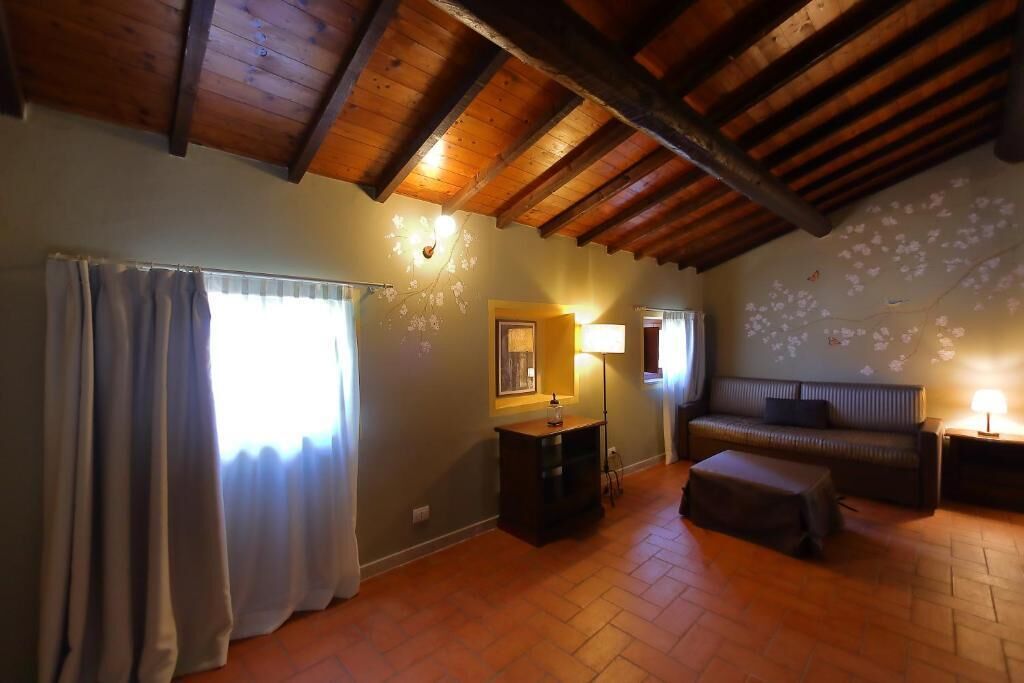 A cozy room with a wooden ceiling, a sofa, a small table, and a lamp.