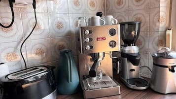 A kitchen with a coffee machine, a toaster, and a kettle.