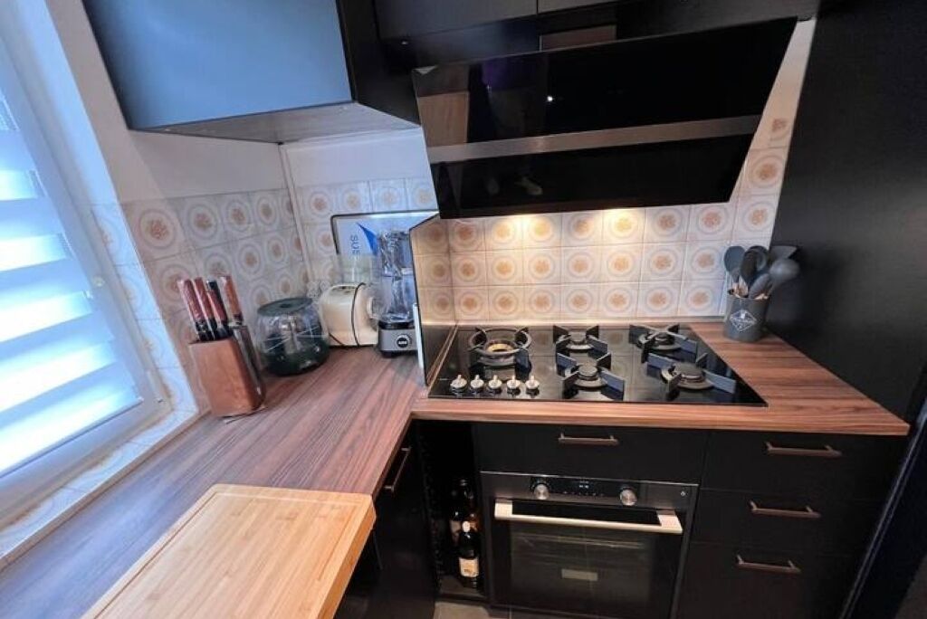 Una cocina compacta con estufa a gas, horno y cafetera.