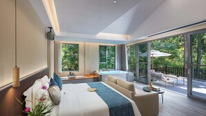 Ein modernes Hotelzimmer mit einem großen Bett, einer Couch, einem kleinen Tisch und einem Balkon mit Blick ins Freie.